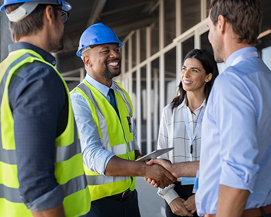 Construction workers talking and shaking hands